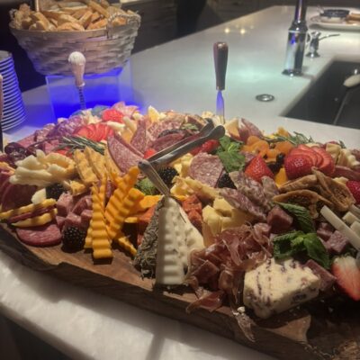 Artful display of salamis, cheese on wooden board